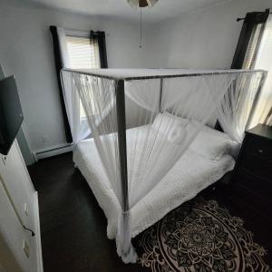 Sofia's Garden في نورث بيرغن: غرفة نوم مع سرير مظلة مع ستائر بيضاء