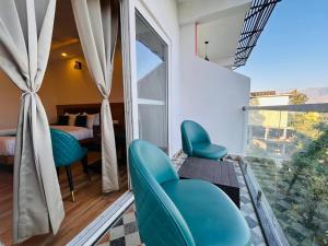 a room with a balcony with blue chairs and a bedroom at Pine Rock Hotel in Mussoorie Peaceful Stay in Mussoorie