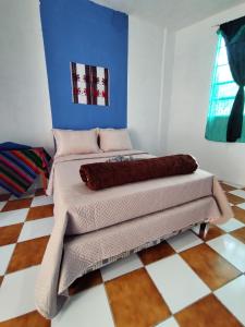 Nawal Hostel في سانتا كروز لاغونا: غرفة نوم مع سرير وأرضية مصدية