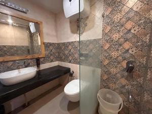 a bathroom with a sink and a toilet and a mirror at Pine Rock Hotel in Mussoorie Peaceful Stay in Mussoorie