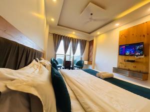 a bedroom with a bed with a tv on the wall at Pine Rock Hotel in Mussoorie Peaceful Stay in Mussoorie +22 photos