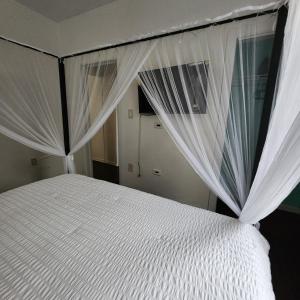 Sofia's Garden في نورث بيرغن: غرفة نوم بسرير ابيض عليه ستائر