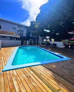a large blue swimming pool on a wooden deck at Pousada Vila Verde in Porto Belo