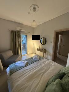 a bedroom with a large bed and a couch at Demis Sea Breeze Apartment in Artemida