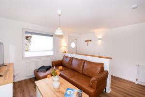una sala de estar con un sofá y una mesa en Alte Liebe 5, en Grömitz