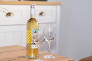Una botella de vino y dos copas de vino en una mesa en Alte Liebe 5, en Grömitz 21 fotos más