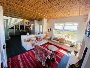 a large living room with a couch and a table at Cape Holly Beach House in Pringle Bay