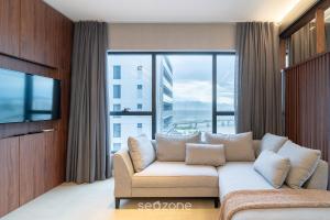 a living room with a couch and a large window at TVT - Luxury studios in the center of Florianópolis in Florianópolis