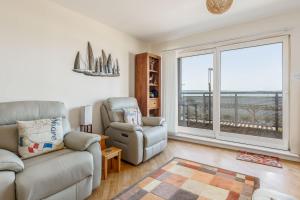 a living room with a couch and a chair and a window at Ahoy - Balcony with Beautiful Harbour Views in Poole +10 photos