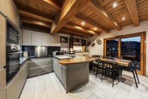 a kitchen with a table and a dining room at Chalet Arpitan - les Carroz - Grand Massif in Les Carroz d'Araches