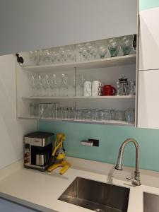 Villa Jardin في كيبوس: طاولة مطبخ مع حوض وكاسات على الأرفف