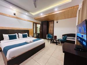 a bedroom with a bed and a flat screen tv at Pine Rock Hotel in Mussoorie Peaceful Stay in Mussoorie