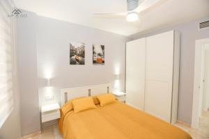 ein weißes Schlafzimmer mit einem Bett mit gelber Bettwäsche in der Unterkunft Horizon Sea Views and Garage in La Herradura