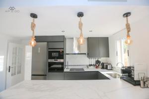 eine Küche mit schwarz-weißen Geräten und Leuchten in der Unterkunft Horizon Sea Views and Garage in La Herradura