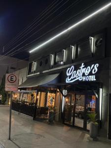 a building with a sign for a music motel at Castro's Hotel in Telêmaco Borba
