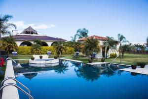 a large swimming pool in front of a house at Hotel Matea San Isidro in Tonatico