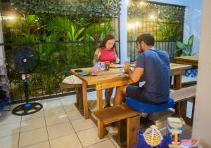 a man and woman sitting at a table in a restaurant at Argdivan Beach Hostel in Sámara