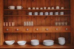a shelf with dishes and cups and plates on it at Spacious 4-bedroom cabin on secluded private land in Miramonte