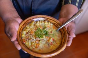eine Person, die eine Schüssel Suppe mit einem Löffel hält in der Unterkunft Hostal el rincón de cusi in Mina Pirquitas + 5 Fotos