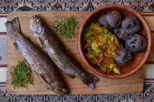 Eine Schüssel mit Fisch und Gemüse auf einem Schneidebrett in der Unterkunft Hostal el rincón de cusi in Mina Pirquitas