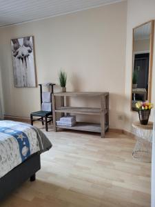 Bonair Gezellig appartement in hartje Wenduine في فينداوني: غرفة نوم بسرير وطاولة ومرآة