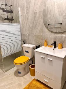 a bathroom with a yellow toilet and a sink at Keur Ébène - Appartement Cosy à Ouakam Batrain in Dakar