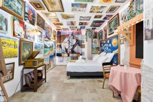 a room with a bed and a wall of paintings at YourSuite Studio Premium à Thème in Chaville +66 photos