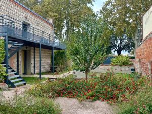 Un edificio de ladrillo con una escalera en un jardín. en Evasions-Dérobade, centre-ville, gare, en Auterive