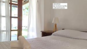 Un dormitorio con una cama blanca y una ventana. en Senda Marina Aparto Hotel, en Punta del Este