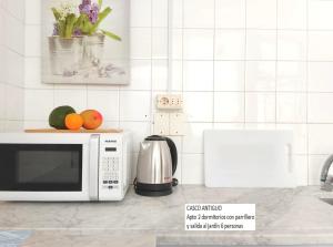 Una cocina con microondas y fruta en la encimera. en Senda Marina Aparto Hotel, en Punta del Este