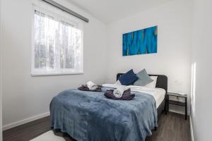 een witte slaapkamer met een bed met handdoeken erop bij Casa Léda Apartment in Szentendre