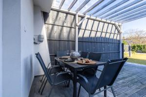 een tafel en stoelen op een patio met een pergola bij Casa Léda Apartment in Szentendre