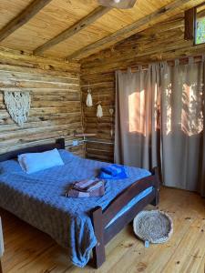 ein Schlafzimmer mit einem Bett in einer Blockhütte in der Unterkunft La retama in Alta Gracia