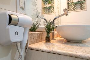 un asciugacapelli su un bancone accanto a un lavandino di Confortável e bem localizado a 300m da praia a CFB Altre 31 foto