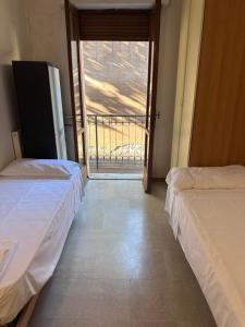 Villa Glori 12 Palace في كريمونا: سريرين في غرفة مع باب للشرفة