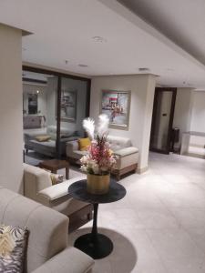 un soggiorno con divani e un tavolo con fiori di فندق أكاليل a Al Masfalah Altre 7 foto