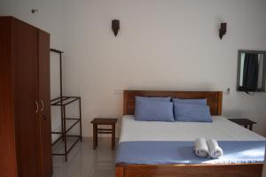 a bedroom with a bed with blue pillows and towels at Villa Shiny Aura - Hikkaduwa in Hikkaduwa