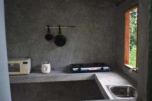 a kitchen with a stove and a microwave and a sink at Villa Shiny Aura - Hikkaduwa in Hikkaduwa +12 photos