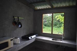 a kitchen with a microwave and a sink and a window at Villa Shiny Aura - Hikkaduwa in Hikkaduwa