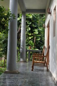 a wooden bench sitting on the porch of a house at Villa Shiny Aura - Hikkaduwa in Hikkaduwa
