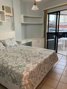 Un dormitorio con una cama y una cocina con una mesa. en Residencial Gabriela, en Itapema