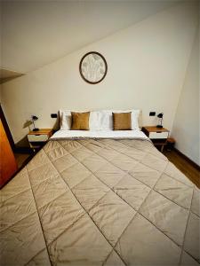 a bedroom with a large bed with a clock on the wall at LOFT EMILIA a Castel Bolognese self check-in in Castel Bolognese