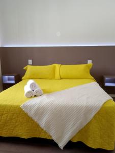 een geel bed met twee handdoeken erop bij Hotel Marciala in Villa Carlos Paz