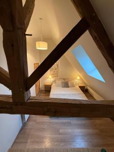 een slaapkamer met een bed op de zolder bij Sur Les Roches in Dracy-lès-Couches