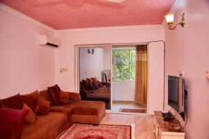 Kilimani Apartment 2 في مدينة زنجبار: غرفة معيشة مع أريكة وتلفزيون