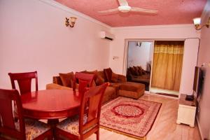 Kilimani Apartment 2 في مدينة زنجبار: غرفة معيشة بها طاولة وأريكة +7 صور