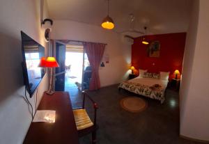 Un dormitorio con una cama y una pared roja. en La Maison Abaka, en Dakar