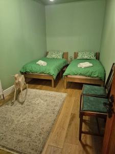 a room with two green beds and a rug at The Ferns in Mitcheldean