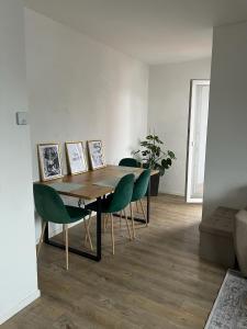 a dining room with a table and green chairs at Alpenblick - Zentralgelegene 2-Zimmer-Wohnung in Kiefersfelden