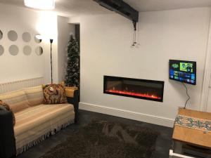 a living room with a couch and a fireplace at The Pathfinder's Retreat - 1 bedroom house for 2-3 guests in Deri